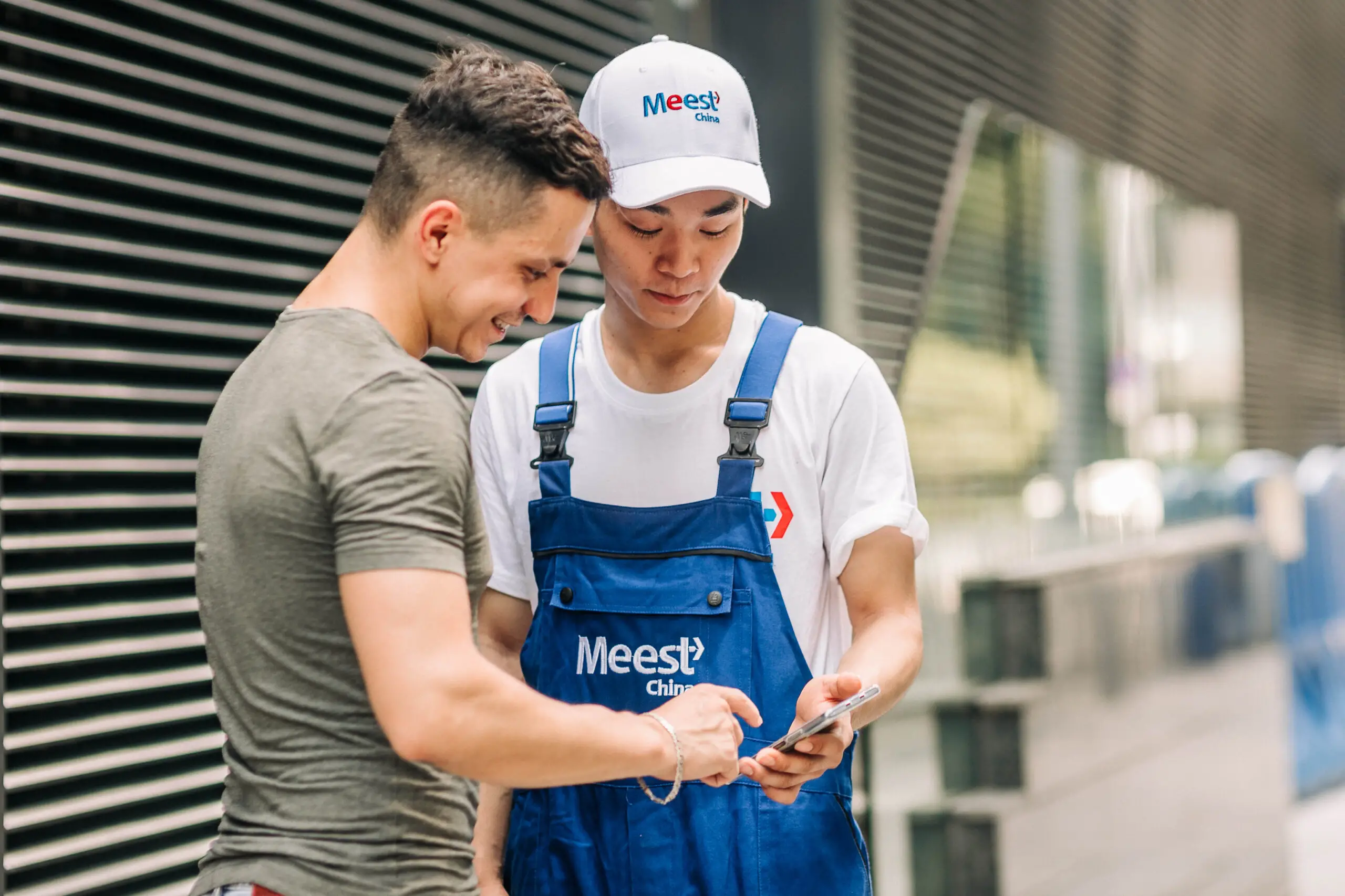 A courier passing a parcel to a man.